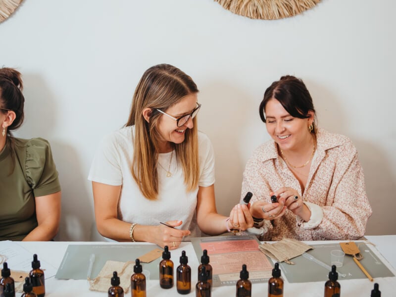 Two smiling women at a perfume making workshop